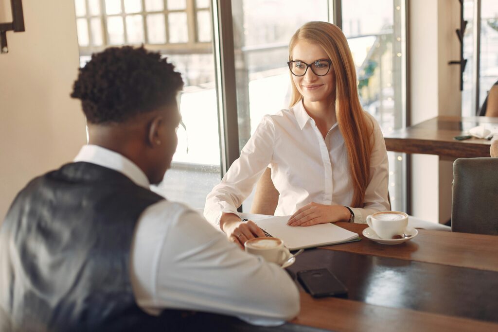 Two professionals engaged in a friendly business meeting in a stylish office setting.